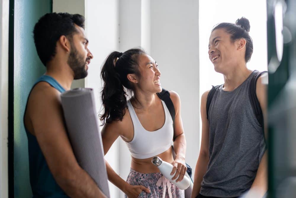 three young asian friends having a casual conversation and laughter at yoga class stock photo